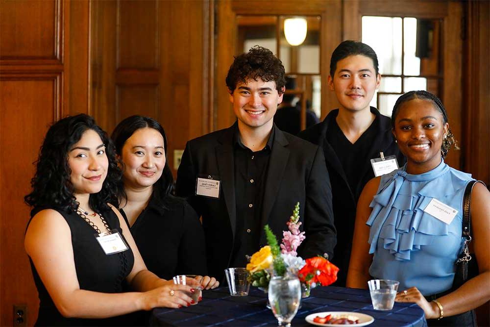 3 female students, 2 male students posing for photo at scholarship dinner event